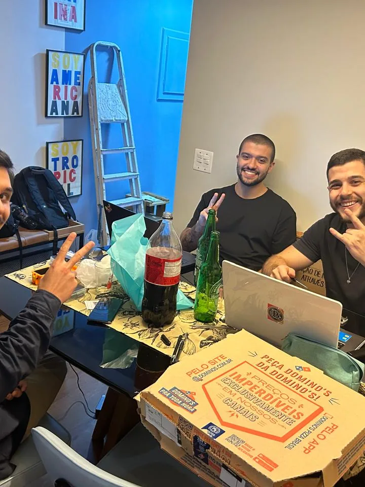 O time da DSEC reunido em volta de uma mesa com caixas de pizza e notebooks